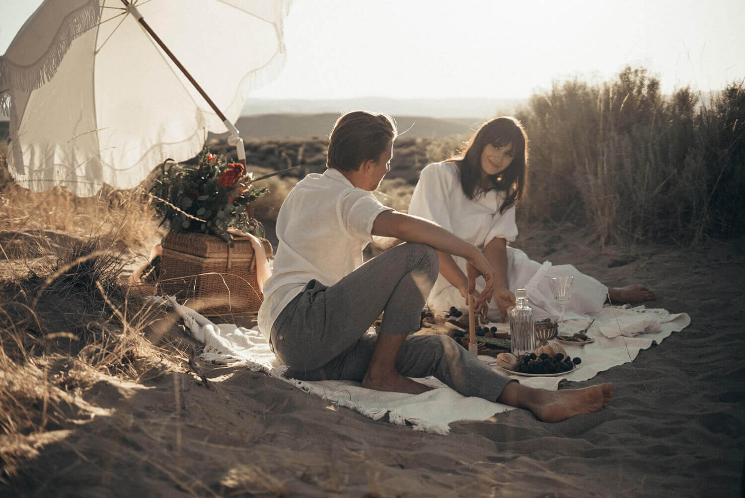 verliebtes Pärchen picknickt zwischen den Dünen