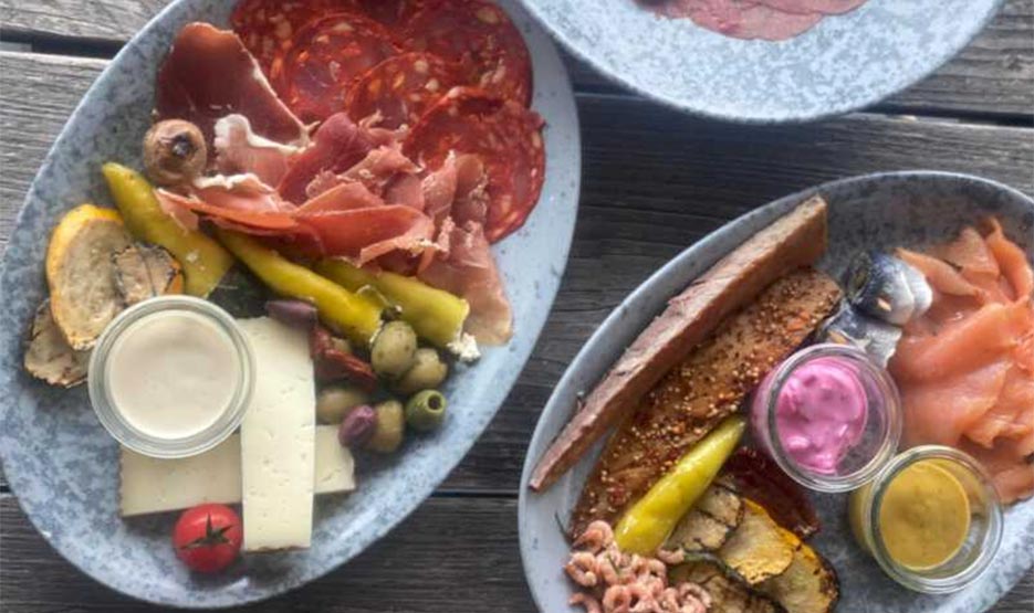 Sandburg-Tapas-03 Nahaufnahme von schön angerichtetem Tintenfisch auf Tomaten